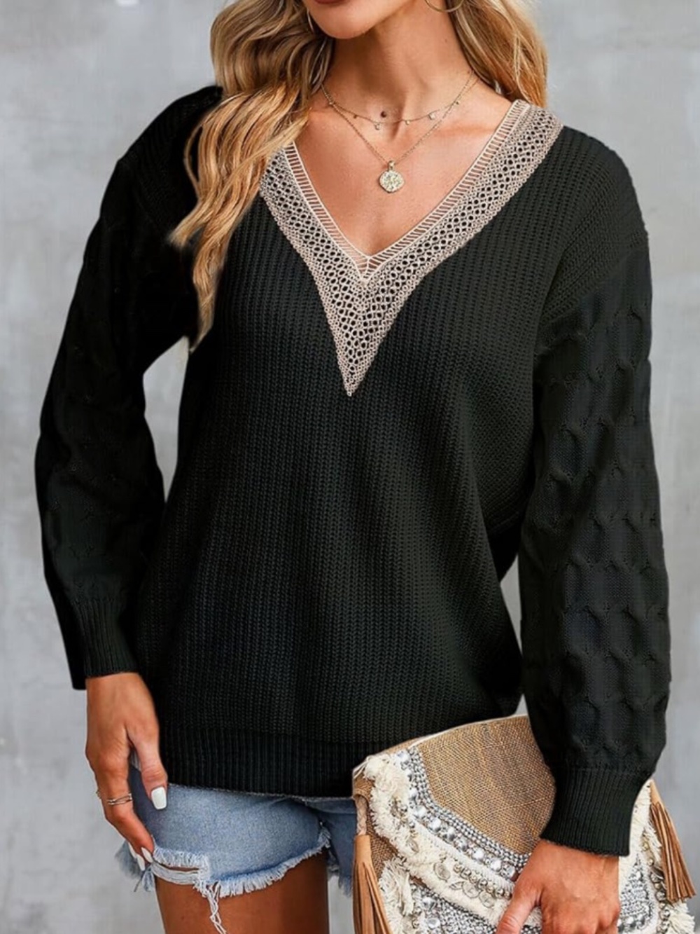 Elegant black V-neck sweater featuring a contrasting cream lace trim. Soft knit